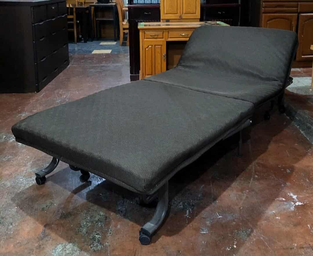Reclining Folding Bed (Category: Bed Frames & Mattresses) located in Manila. Submitted by luckyfalcon.510cbb (Listing ID 1428741692, Image 1). Description: Folding bed features a dark-colored, padded surface and a sturdy metal frame. It has wheels for easy movement and can be folded for storage. The bed can be adjusted to different positions, including a flat and a reclined position. Dimensions are approximately H-12, L-76, and W-36 inches..