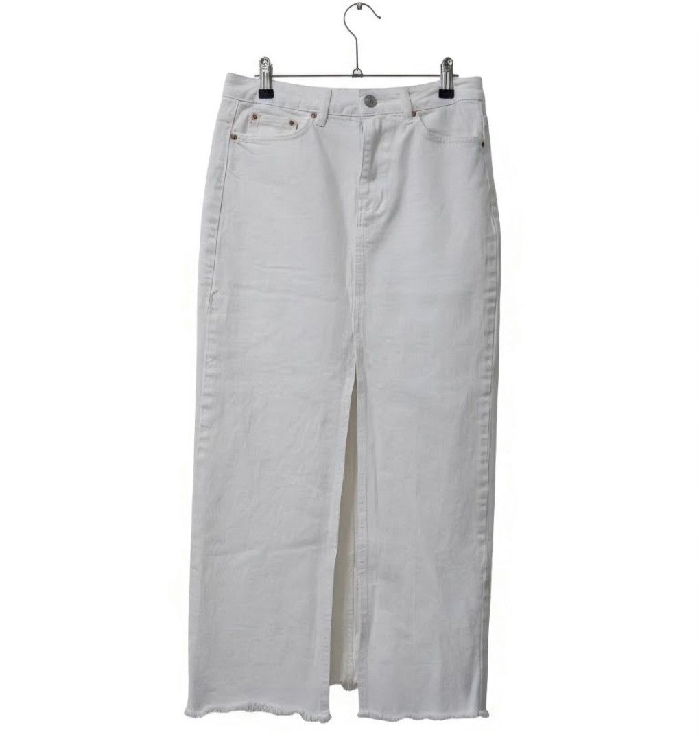 Stradivarius White Denim Maxi Skirt (Category: Skirts) located in Manila. Submitted by aclosetsale (Listing ID 1428758820, Image 1). Description: White denim maxi skirt with a front slit. Features a classic five-pocket design and a button and zipper closure. The hemline has a raw, frayed edge. The skirt is hanging on a hanger. A versatile piece that can be dressed up or down..