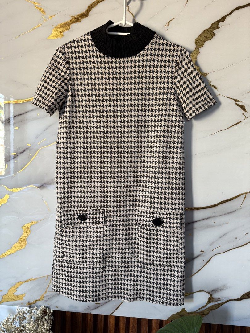 Zara Trafaluc Houndstooth Dress (Category: Dresses) located in Marikina City. Submitted by declutter_keni24 (Listing ID 1428695657, Image 1). Description: Super nice and lakas mkasosyal😍 Dress features a houndstooth pattern and a black ribbed turtleneck. It has short sleeves and two front pockets with black buttons. The dress is from Zara Trafaluc and has a size indicated on the label. The dress is a shift style..