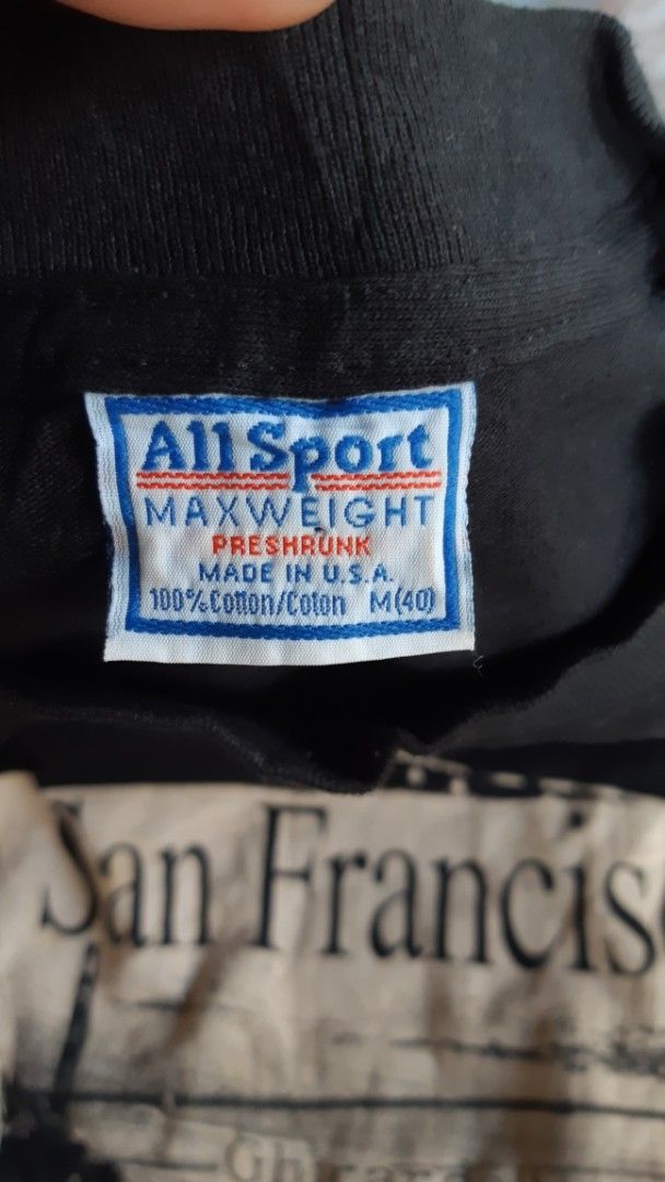 All Sport San Francisco Graphic Tee (Category: Tshirts & Polo Shirts ) located in Malaybalay. Submitted by rielstuff (Listing ID 1428952947, Image 3). Description: Black t-shirt featuring a San Francisco graphic print. The print includes images of the Golden Gate Bridge, cable cars, and other landmarks. The tag indicates it is an All Sport Maxweight, preshrunk, made in the USA, and is a size M (40). It is made of 100% cotton..