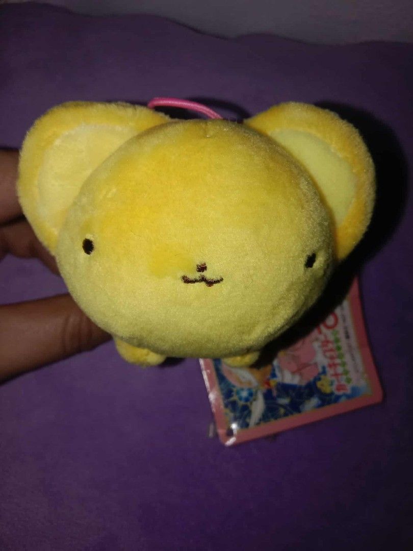 Cardcaptor Sakura Kero-chan Plush Keychain (Category: Plushies & Soft Toys) located in Dagupan City. Submitted by gentlemountain-afad44 (Listing ID 1428807258, Image 1). Description: Adorable Kero-chan plush keychain from Cardcaptor Sakura. Features a yellow body with small black eyes and a cute little mouth. Includes a pink string for easy attachment. Comes with the original tag. Perfect for fans of the series or collectors..