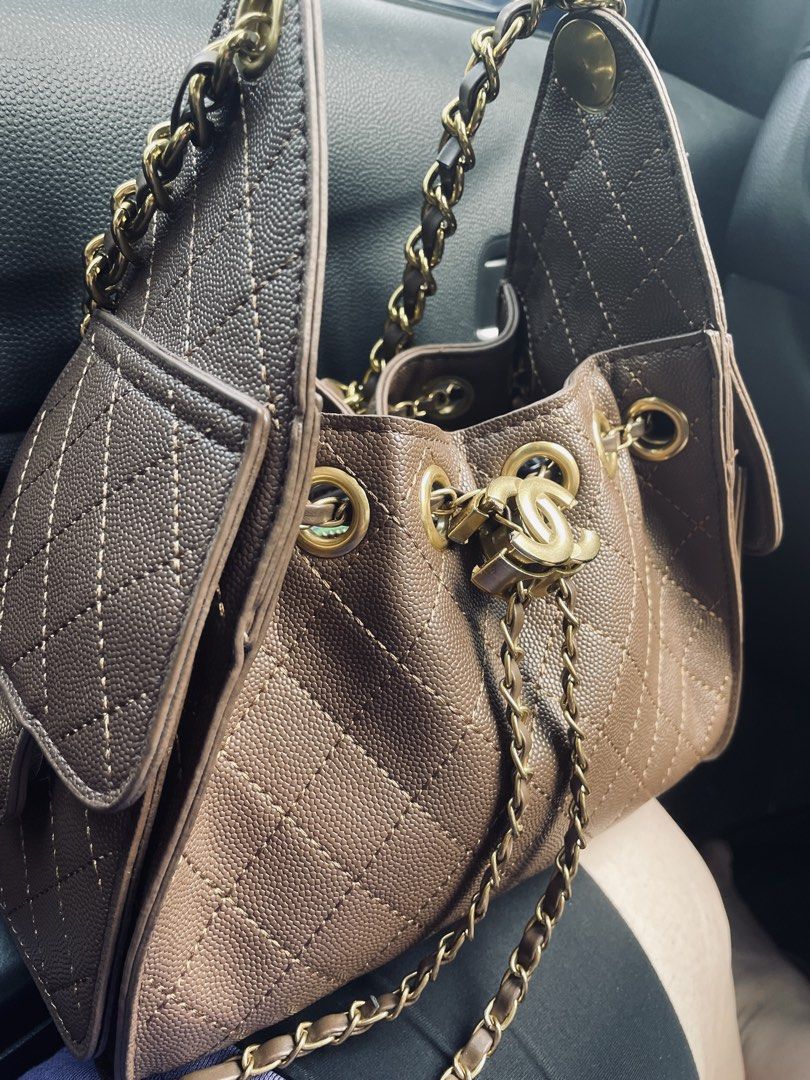 Drawstring bag (Category: Shoulder Bags) located in Singapore. Submitted by Jassslin72 (Listing ID 1428894669, Image 1). Description: Like new milk tea colour drawstring bag. A little chip on the side logo. Black shoulder bag is brand new and selling at $88.