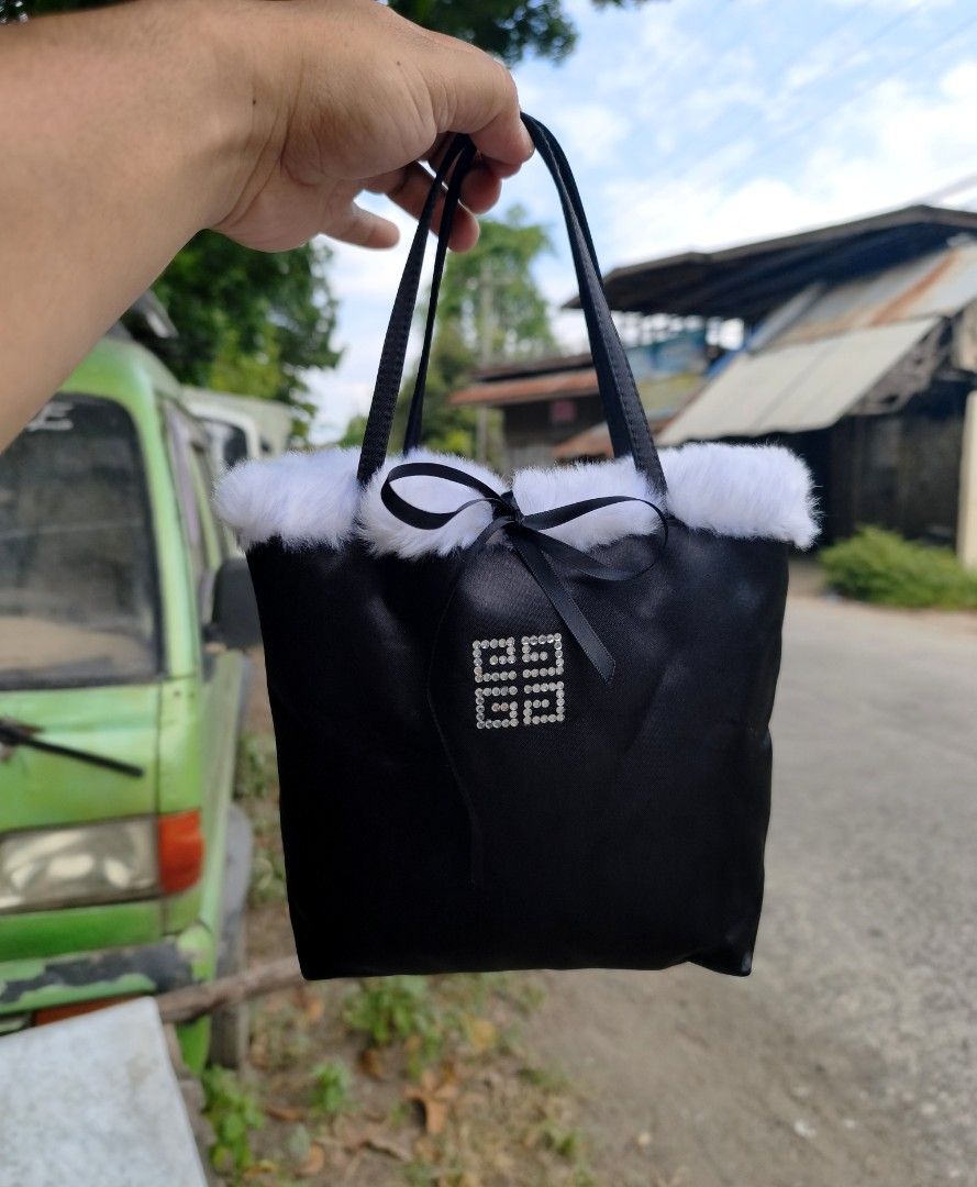 Givenchy Black Tote Bag with Fur Trim (Category: Luxury Bags & Wallets) located in Digos. Submitted by emmanuel28 (Listing ID 1428936166, Image 1). Description: Authntic Y2K Satin tote with Fur Rhinestones logo Fur material inside for extra comfort for your items especially phones and wallets Size (approx.) Height 18cm, Width 18cm, Depth 8.5cm Handle height: 13cm from the bag Rank SA No issue Location: Davao del sur Buyer shoulders shipping fee.