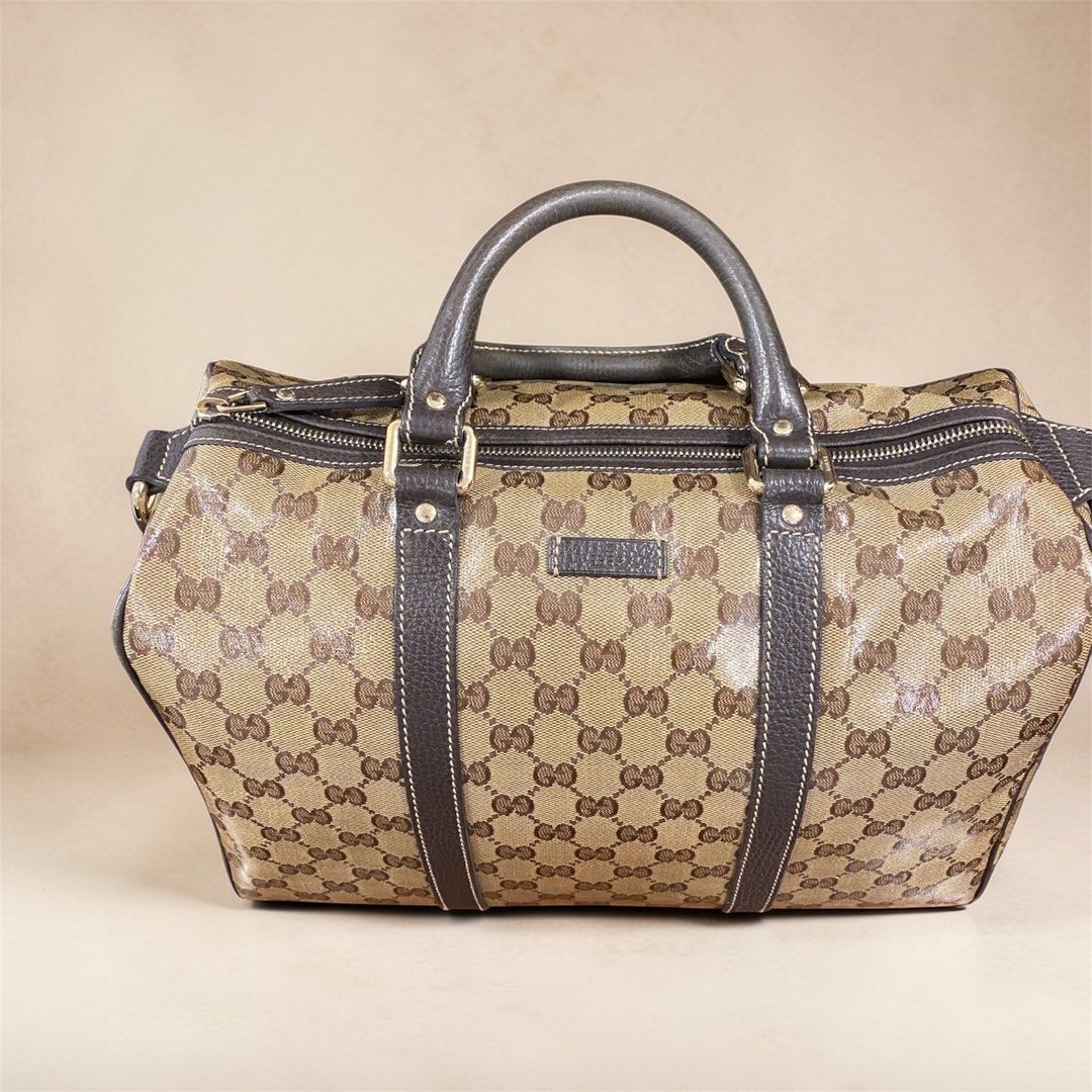 Gucci GG Crystal Joy Boston Bag (Category: Luxury Bags & Wallets) located in Mandaluyong City. Submitted by loved_curated (Listing ID 1428819090, Image 1). Description: Gucci Boston bag featuring the iconic GG monogram pattern. It has a brown leather trim and handles. The bag has a zip closure and a rectangular leather patch with the Gucci logo. Comes with dust bag. .
