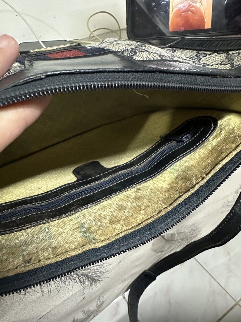 Gucci Shoulder Bag with Web Stripe (Category: Luxury Bags & Wallets) located in Makati City. Submitted by i_am-sanguine (Listing ID 1428925166, Image 3). Description: Vintage Gucci shoulder bag featuring the iconic GG monogram canvas with a web stripe. The bag has a dark blue leather trim and a shoulder strap. The interior includes a zippered pocket. The bag has Gucci logo tag inside..
