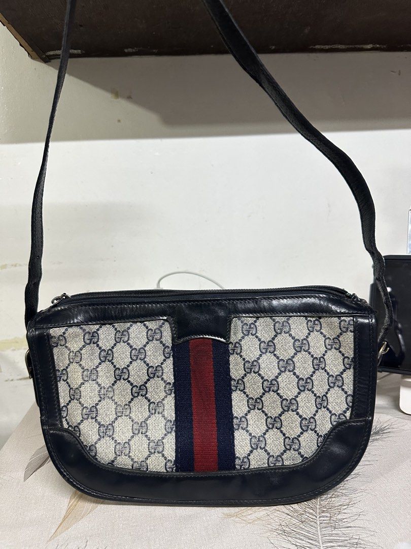 Gucci Shoulder Bag with Web Stripe (Category: Luxury Bags & Wallets) located in Makati City. Submitted by i_am-sanguine (Listing ID 1428925166, Image 2). Description: Vintage Gucci shoulder bag featuring the iconic GG monogram canvas with a web stripe. The bag has a dark blue leather trim and a shoulder strap. The interior includes a zippered pocket. The bag has Gucci logo tag inside..