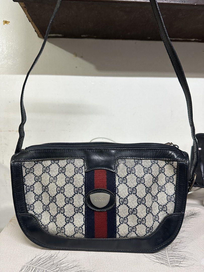 Gucci Shoulder Bag with Web Stripe (Category: Luxury Bags & Wallets) located in Makati City. Submitted by i_am-sanguine (Listing ID 1428925166, Image 1). Description: Vintage Gucci shoulder bag featuring the iconic GG monogram canvas with a web stripe. The bag has a dark blue leather trim and a shoulder strap. The interior includes a zippered pocket. The bag has Gucci logo tag inside..