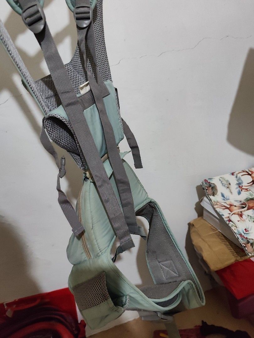 Infantino Baby Carrier (Category: Carriers & Slings) located in Taytay. Submitted by PrelovedCollections (Listing ID 1428866236, Image 2). Description: Infantino baby carrier is in a light teal color. It features adjustable straps and a mesh back for breathability. The carrier has a front pocket and a supportive design for the baby.. loc: taytay rizal ship via tiktok co gcash ready.