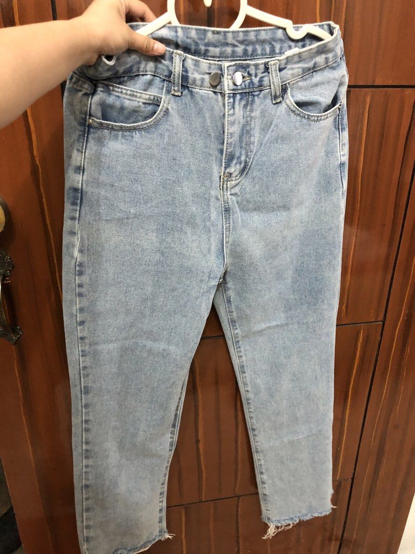 Light Blue Denim Jeans (Category: Jeans) located in Pateros City. Submitted by downsizin (Listing ID 1428935860, Image 1). Description: Size 29 inches waist size, 37 length Light blue denim jeans with a straight leg cut. Features two front pockets and two back pockets. The jeans have a button and zipper closure. The hemline is frayed. The tag shows the size and material composition. The jeans are held on a white hanger..