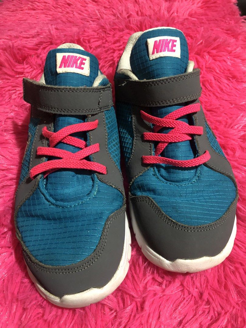 RePriced 390! Nike Kids' Sneakers (Category: Babies & Kids Fashion) located in Mandaluyong City. Submitted by jennyitems (Listing ID 1428975016, Image 1). Description: 👟 These Nike sneakers feature a teal and gray design with pink laces. 👟 They have a velcro strap for easy wear and a white sole. 👟 The Nike logo is visible on the tongue and side of the shoe. 👟 The soles show some wear..