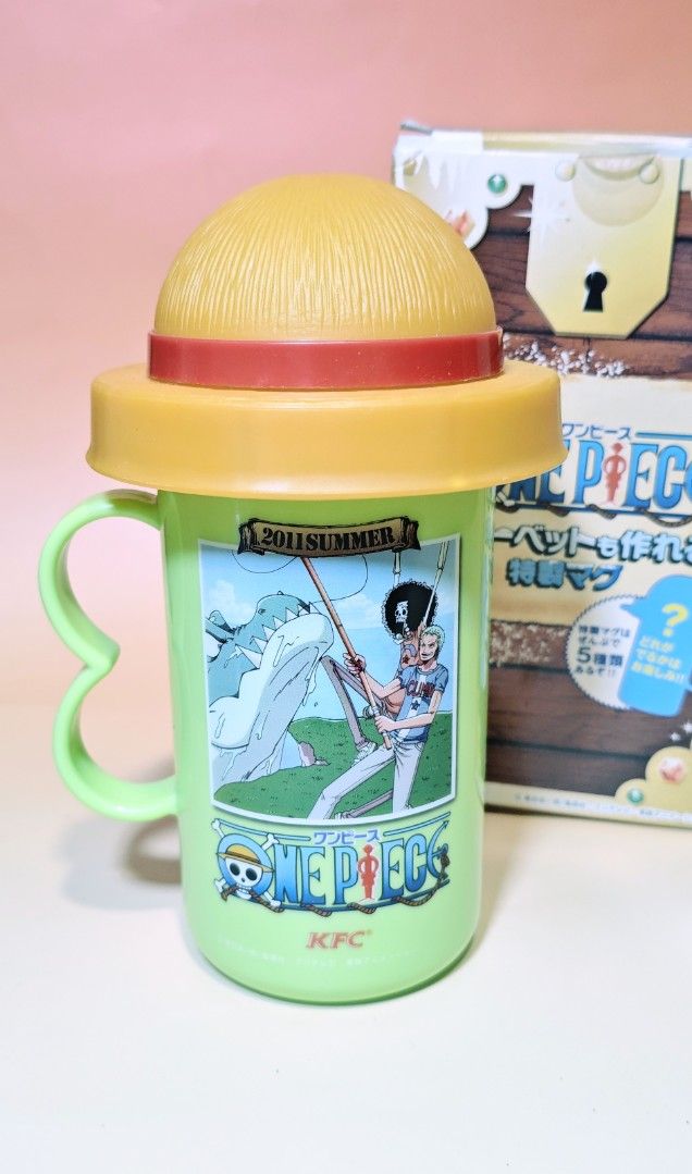 One Piece Sherbet Mug x KFC (Category: Water Bottles & Tumblers) located in Manila. Submitted by yourfavoritethings7 (Listing ID 1428843202, Image 2). Description: Collectible One Piece tumbler from KFC. Features illustrations of Zoro, Sanji, and other characters. Comes with a straw hat-shaped lid and a handle. The tumbler is green with a yellow lid and handle. Includes the original box..