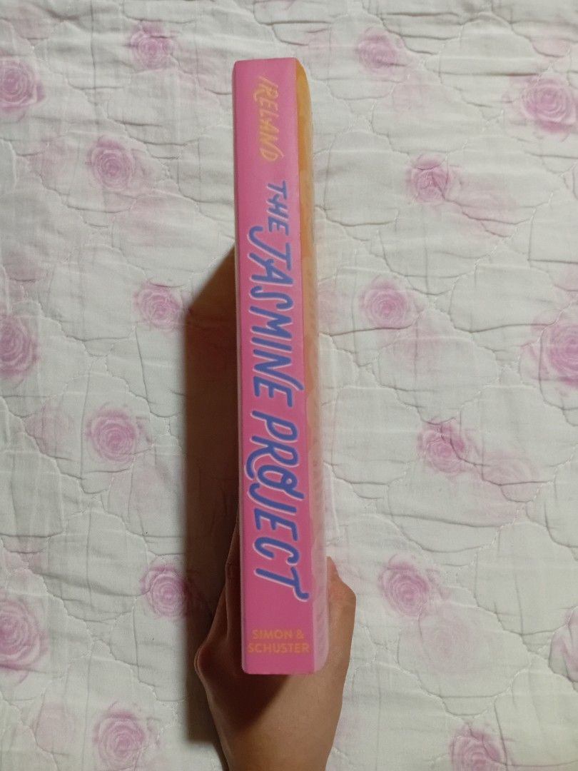 The Jasmine Project by Meredith Ireland Preloved (Category: Storybooks) located in San Juan City. Submitted by bisoussofia (Listing ID 1428906248, Image 2). Description: Copy of "The Jasmine Project" by Meredith Ireland. The book has a pink and orange cover with a girl holding a phone. The spine of the book shows the title and author's name. The back of the book has text..