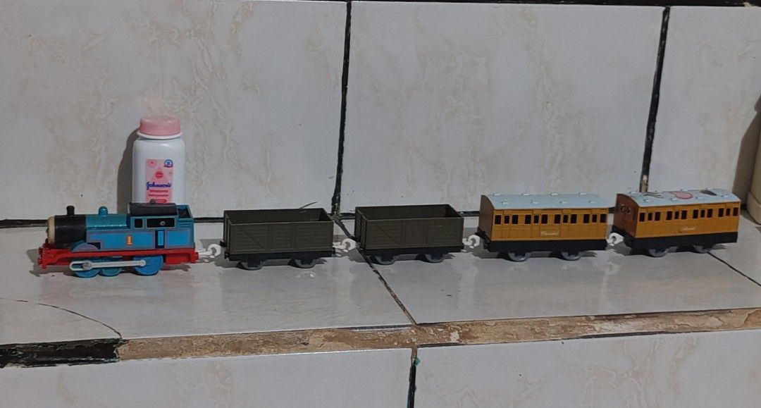 Thomas the Tank Engine Train Set 1992 - 2002 (Category: Vehicle & Diecast Models) located in Pasig City. Submitted by geraldnee28280 (Listing ID 1428967160, Image 1). Description: Thomas the Tank Engine train set. It includes the Thomas engine, two cargo cars, and two passenger cars named Annie and Clarabel. The engine is blue with red accents. The passenger cars are yellow. The train set is made by Tomy and is marked as made in Thailand..