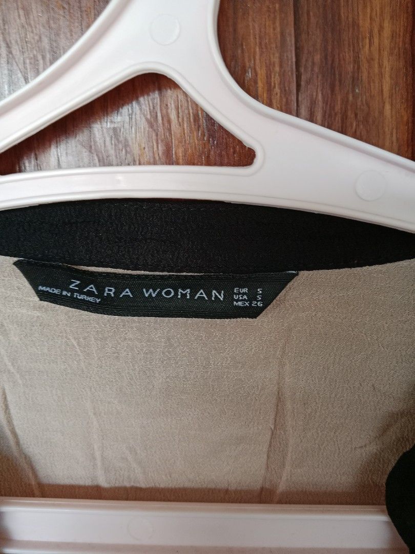 Zara Woman Top - Size S (Category: Sleeveless) located in Oras. Submitted by preloved4less88 (Listing ID 1428799164, Image 2). Description: Zara Woman top in size S. Features a V-neck design with black trim. The top has short sleeves with a ruffled detail. The color is a light peach or beige. Made in Turkey..
