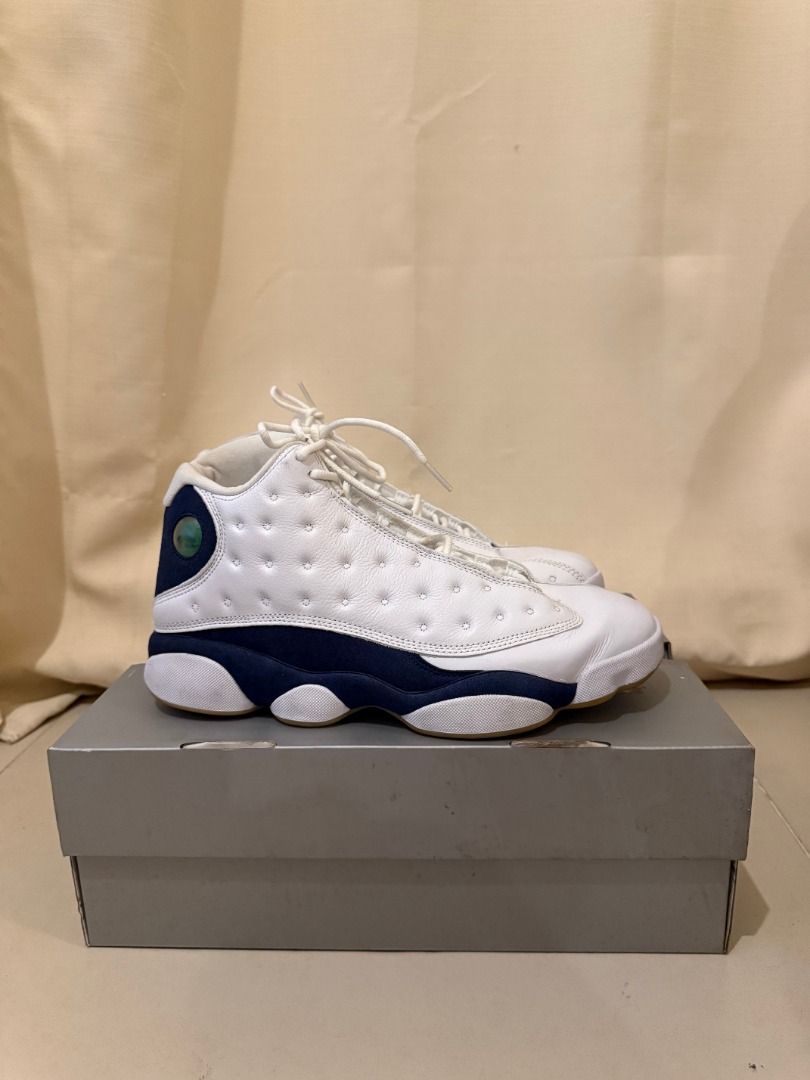 Air Jordan 13 White/Navy Blue (Category: Sneakers) located in Taytay. Submitted by amandagianan (Listing ID 1429141393, Image 2). Description: Air Jordan 13 sneakers in white and navy blue. The shoes have a white leather upper with navy blue accents and a gum sole. The size is US 10.5 The shoes come with the original box. The overall design is a classic basketball shoe..