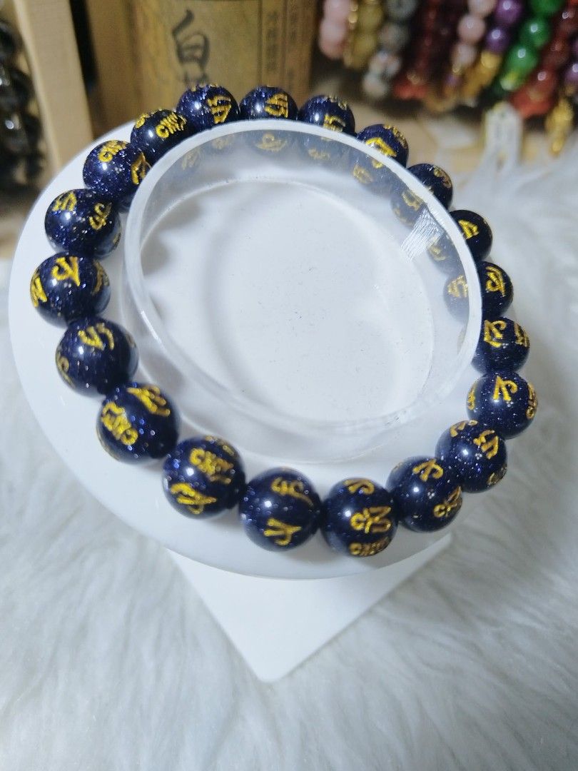 Blue Sandstone Bracelet with Gold Lettering (Category: Bracelets) located in Quezon City. Submitted by ctraex (Listing ID 1429023716, Image 1). Description: Bracelet features dark blue sandstone beads with gold-colored lettering. The beads are strung together on an elastic band. It is a stylish accessory that can be worn daily or for special occasions. The gold lettering adds a touch of elegance to the bracelet..