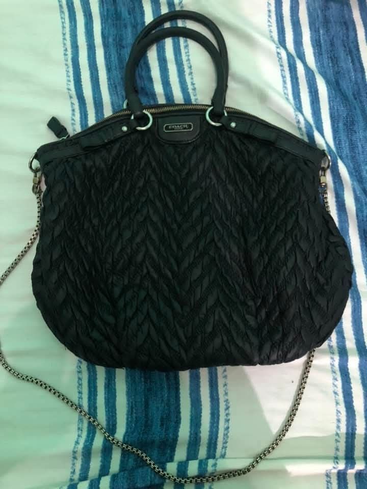 Coach Black Quilted Shoulder Bag (Category: Luxury Bags & Wallets) located in Pugo. Submitted by abshopfinity (Listing ID 1429158814, Image 2). Description: Black Coach shoulder bag with a quilted design. Features a top handle and a chain strap. The interior has a blue lining and a Coach label with the serial number M1270-718834. Includes a zipper closure and a Coach logo on the front. The bag has a unique, textured pattern..