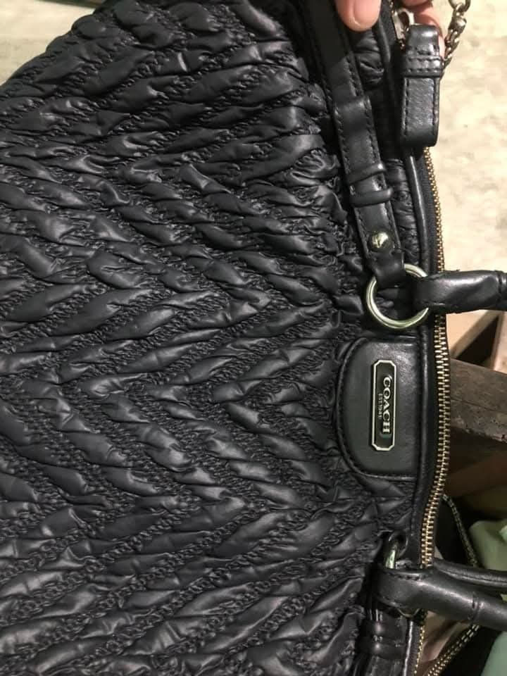 Coach Black Quilted Shoulder Bag (Category: Luxury Bags & Wallets) located in Pugo. Submitted by abshopfinity (Listing ID 1429158814, Image 3). Description: Black Coach shoulder bag with a quilted design. Features a top handle and a chain strap. The interior has a blue lining and a Coach label with the serial number M1270-718834. Includes a zipper closure and a Coach logo on the front. The bag has a unique, textured pattern..