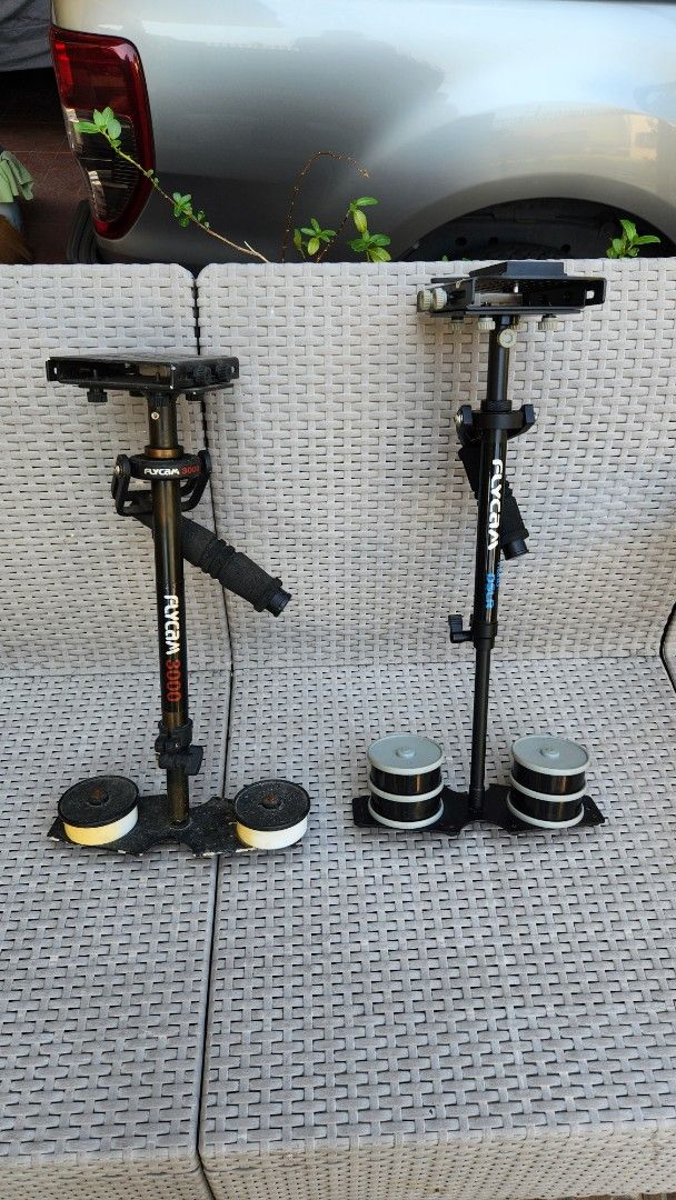 Flycam 3000 & Nano DSLR Stabilizer (Category: Cameras) located in Antipolo. Submitted by luislasi (Listing ID 1429092590, Image 3). Description: Listing includes a Flycam 3000 and a Nano DSLR stabilizer, both with one carrying bag. The Flycam 3000 has a black handle and a red "3000" marking. The Nano DSLR stabilizer is black with white "Flycam" and "nano DSLR" markings. Both stabilizers include counterweights. This lot is buy buy 1 take 1. As is 