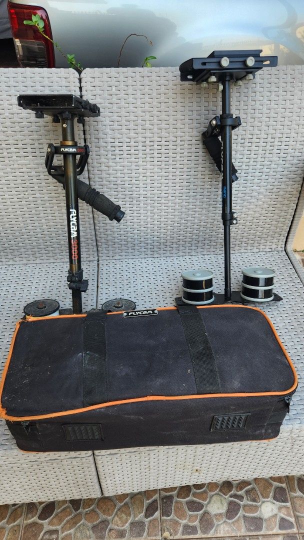 Flycam 3000 & Nano DSLR Stabilizer (Category: Cameras) located in Antipolo. Submitted by luislasi (Listing ID 1429092590, Image 1). Description: Listing includes a Flycam 3000 and a Nano DSLR stabilizer, both with one carrying bag. The Flycam 3000 has a black handle and a red "3000" marking. The Nano DSLR stabilizer is black with white "Flycam" and "nano DSLR" markings. Both stabilizers include counterweights. This lot is buy buy 1 take 1. As is 