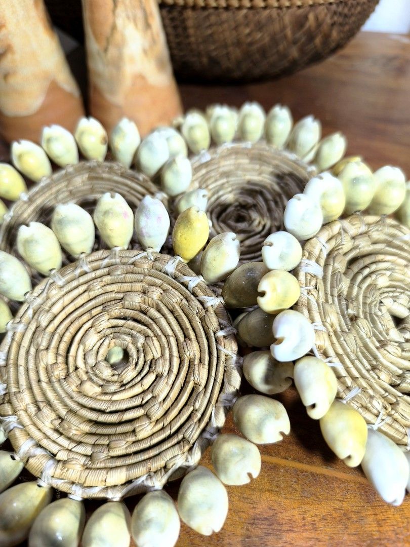 Handmade Woven Coaster with Shells (Category: Other Kitchenware & Tableware) located in Pangil. Submitted by kopee_matcha (Listing ID 1429059786, Image 2). Description: 5 pcs Handmade coaster featuring a woven design with a spiral pattern. It is adorned with multiple shells around the edges. It is suitable for placing cups or glasses on a table to protect the surface..