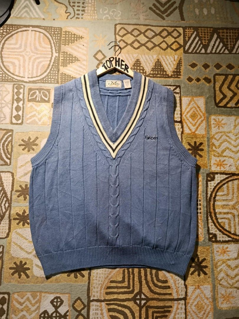 IZOD Blue Knit Vest (Category: Vests) located in Muntinlupa City. Submitted by topher3501 (Listing ID 1429068728, Image 1). Description: IZOD vest features a classic V-neck design with a cable knit detail. It has a blue color with cream and black accents on the neckline. It has the IZOD logo on the chest..