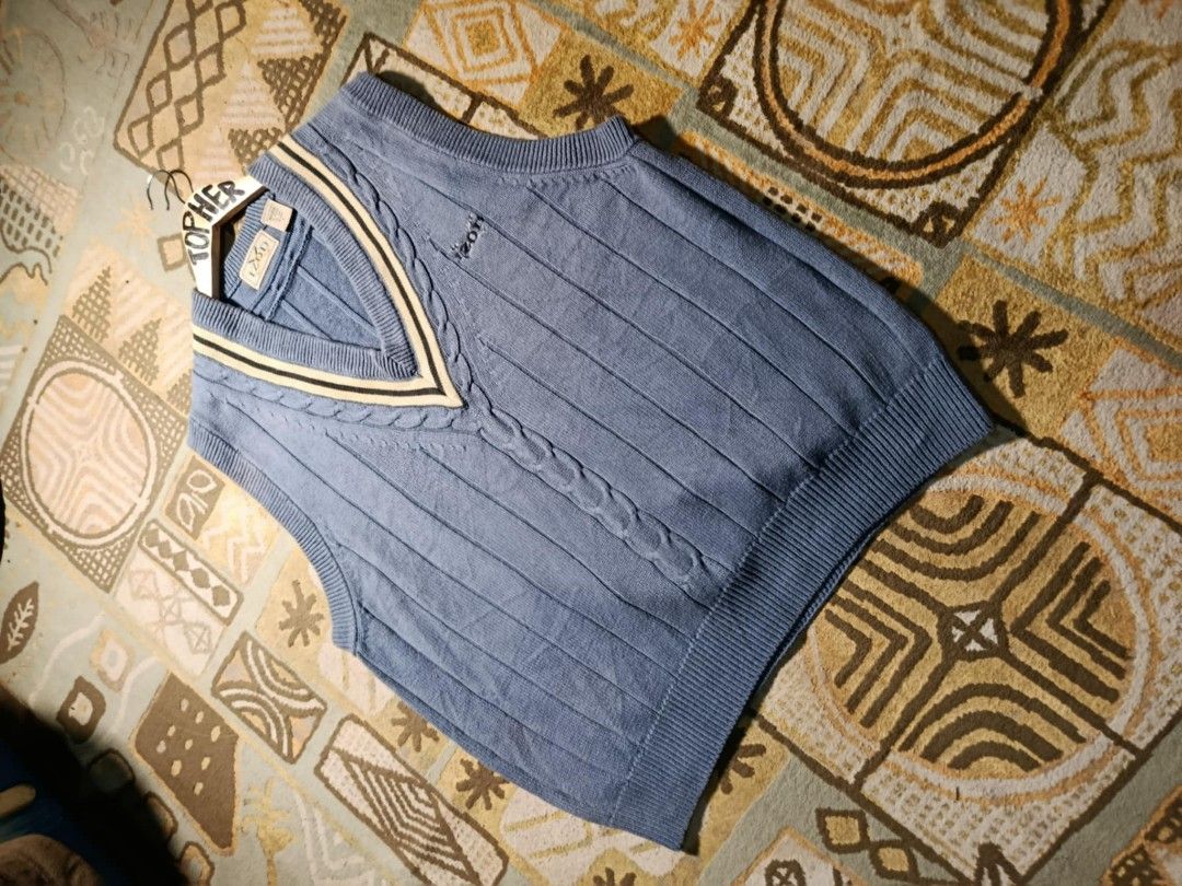 IZOD Blue Knit Vest (Category: Vests) located in Muntinlupa City. Submitted by topher3501 (Listing ID 1429068728, Image 2). Description: IZOD vest features a classic V-neck design with a cable knit detail. It has a blue color with cream and black accents on the neckline. It has the IZOD logo on the chest..