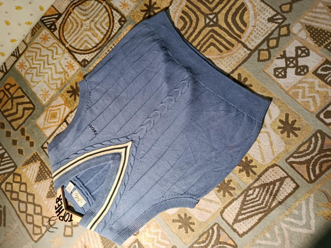 IZOD Blue Knit Vest (Category: Vests) located in Muntinlupa City. Submitted by topher3501 (Listing ID 1429068728, Image 3). Description: IZOD vest features a classic V-neck design with a cable knit detail. It has a blue color with cream and black accents on the neckline. It has the IZOD logo on the chest..
