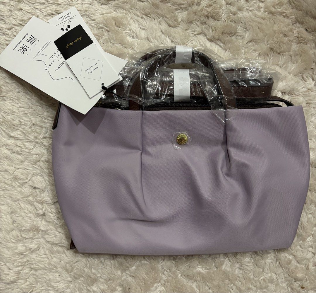 Legato Largo (Category: Luxury Bags & Wallets) located in Batangas. Submitted by aveena0413 (Listing ID 1429099816, Image 2). Description: Brand: Legato Largo Model: LH-L0005 Kataraku (Water-Repellent Nylon Mini Shoulder) Color: Lavender (Japan Design) Condition: Brand new, bought in Japan Features: • Water-repellent nylon — good for light rain and everyday use ￼ • Compact yet practical — fits essentials like phone, wallet, keys, and small access