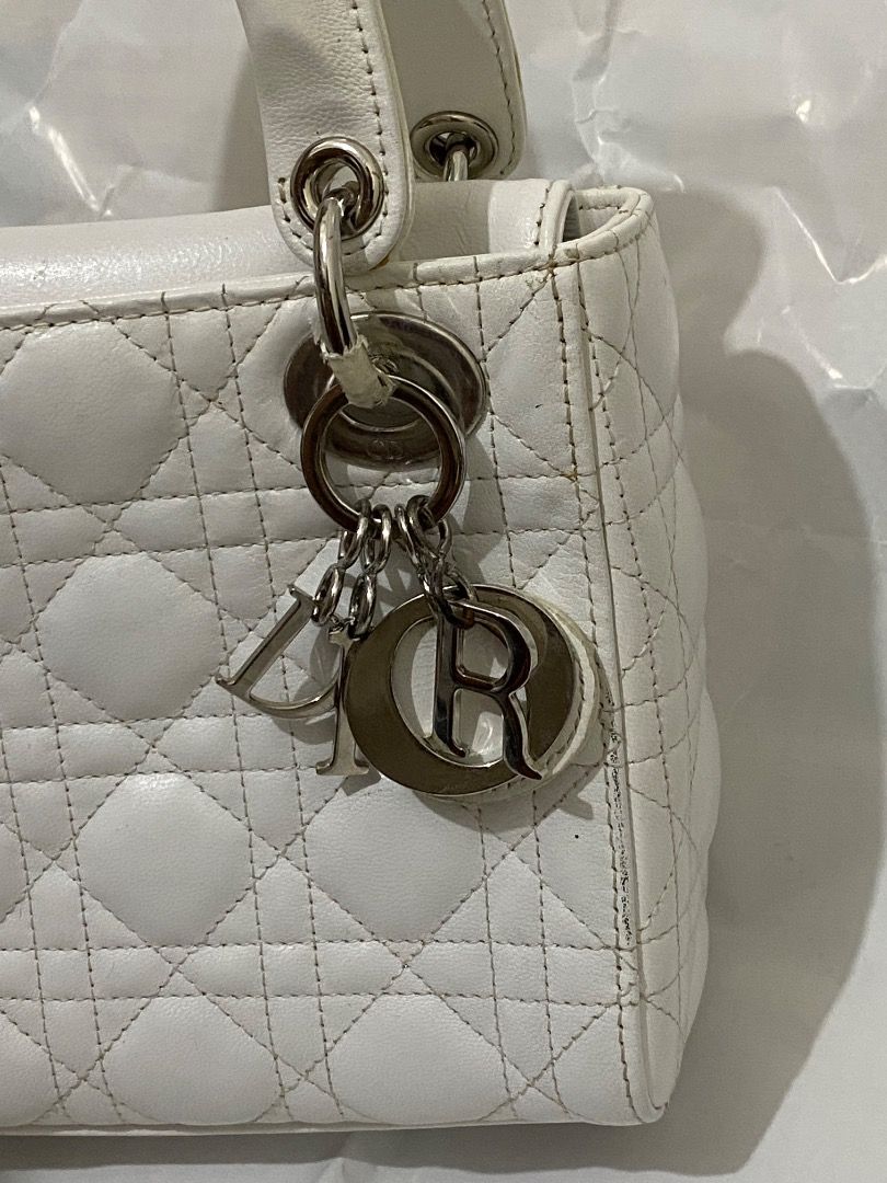 mini Lady Dior White Handbag (Category: Luxury Bags & Wallets) located in Paete. Submitted by ladder_leynn (Listing ID 1429150058, Image 2). Description: White Lady Dior handbag. Features a quilted design and top handles. Includes Dior charms. Silver-tone hardware is visible. The bag has a structured shape..