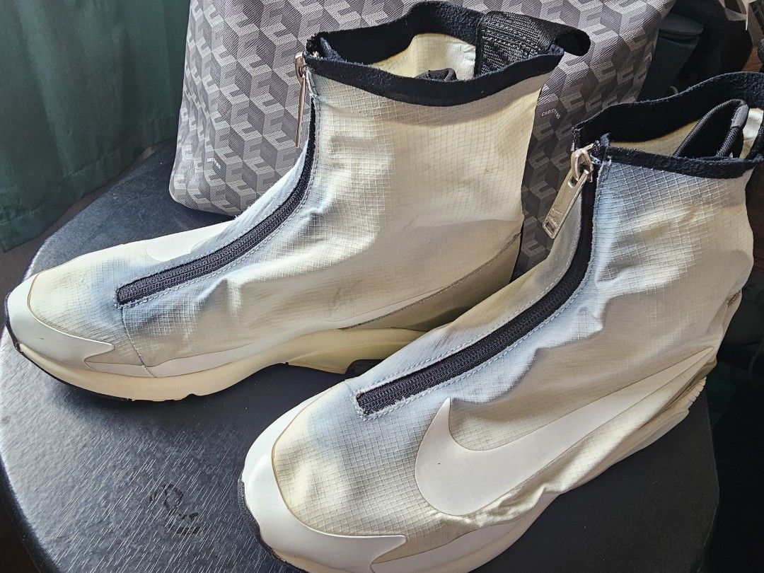 Nike Air Max 180 High Top Sneakers (Category: Sneakers) located in Mandaluyong City. Submitted by bethco (Listing ID 1429034751, Image 1). Description: Nike Air Max 180 high-top sneakers. Features a zip-up design with a white and black color scheme. The sole has a visible Air Max unit. The size is 10.5. The shoes have a unique design with a mix of materials. The soles show some wear. free shipping via j&t visible stains.