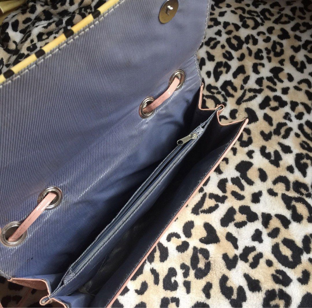 Pink and Yellow Handbag with Chain Strap (Category: Shoulder Bags) located in Mandaluyong City. Submitted by jennyitems (Listing ID 1429161627, Image 2). Description: 👜 Stylish handbag featuring a unique design with a chain strap. 🎀 The bag has a pink exterior with a yellow and black dotted pattern on the front. 🎀 It includes a main compartment with a zipper pocket and a magnetic closure. 🎀 The bag also has a pink interior lining and a detach