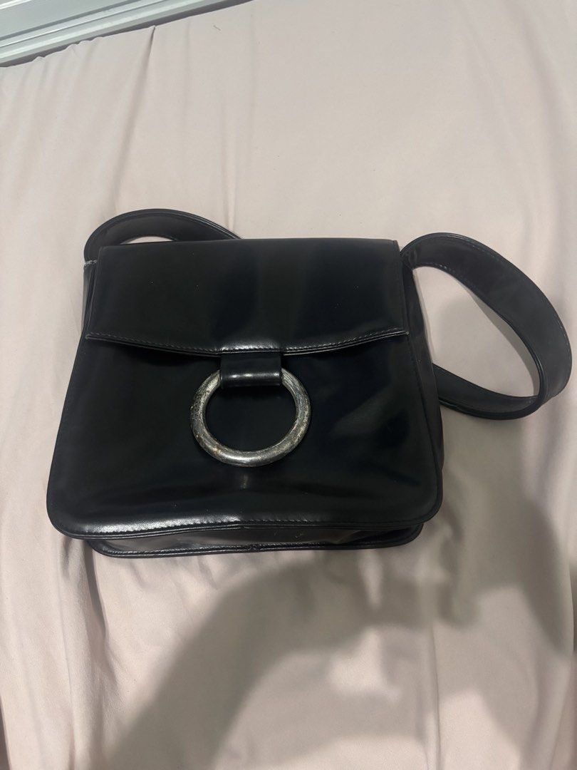 Sequoia Black Shoulder Bag (Category: Luxury Bags & Wallets) located in Victoria. Submitted by eliphalez (Listing ID 1429148803, Image 1). Description: Black shoulder bag by Sequoia. Features a flap closure with a silver-toned ring detail. The exterior is a glossy black material. The bag is a rectangular shape. Issue nasa pic na.