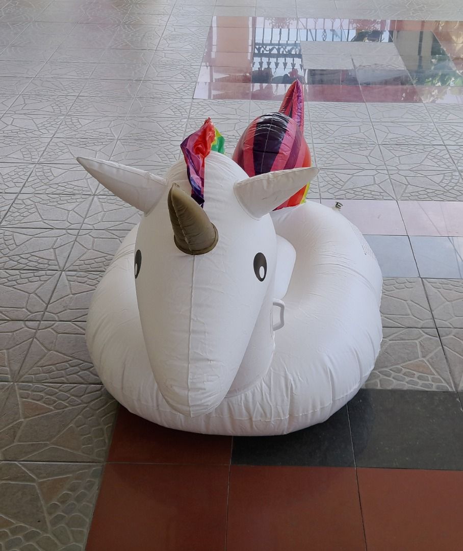 Unicorn Inflatable Pool Float (Category: Infant Playtime) located in Kuala Lumpur. Submitted by evelyncrochet (Listing ID 1429112461, Image 1). Description: Inflatable pool float is shaped like a white unicorn with a rainbow mane and tail. It has a gold horn and black eyes. The float has a circular base for sitting and handles for holding on. It is designed for use in a pool or other body of water..