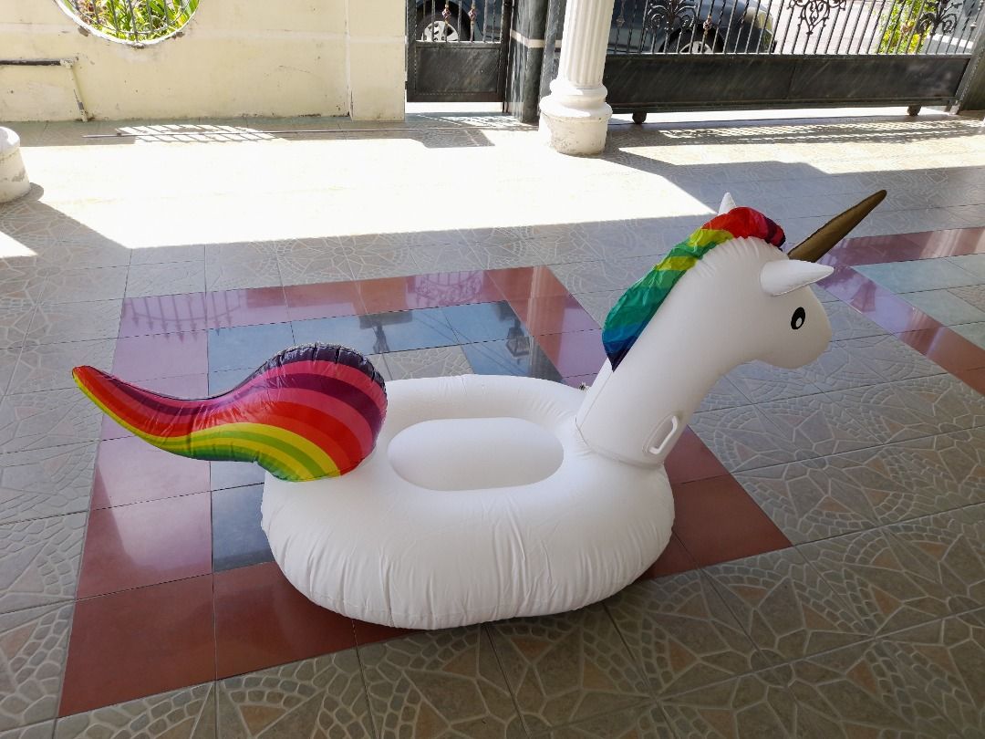 Unicorn Inflatable Pool Float (Category: Infant Playtime) located in Kuala Lumpur. Submitted by evelyncrochet (Listing ID 1429112461, Image 2). Description: Inflatable pool float is shaped like a white unicorn with a rainbow mane and tail. It has a gold horn and black eyes. The float has a circular base for sitting and handles for holding on. It is designed for use in a pool or other body of water..