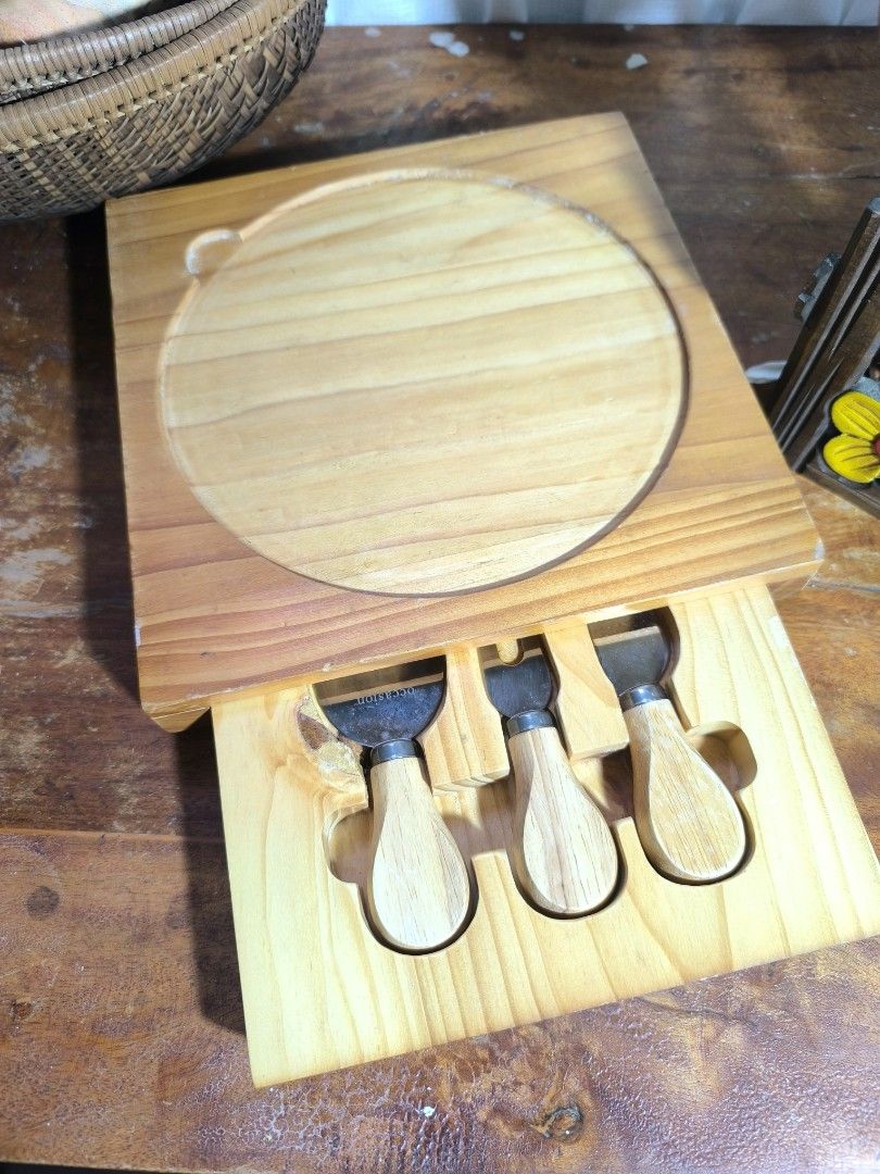 Wooden Cheese Board Set with Knives (Category: Knives & Chopping Boards) located in Pangil. Submitted by kopee_matcha (Listing ID 1429075881, Image 1). Description: Cheese board set includes a wooden board with a circular inset and a drawer containing three cheese knives. The knives have wooden handles and stainless steel blades. The board is square-shaped with a natural wood finish..