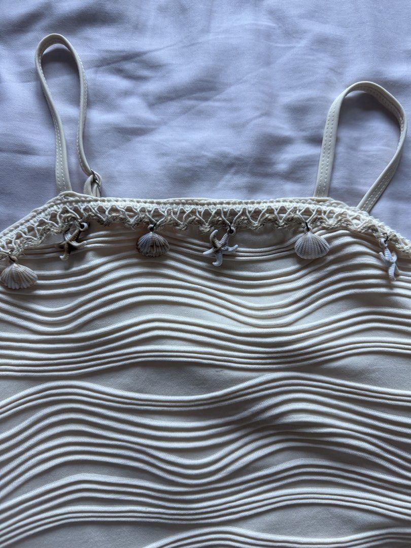 10Y Cream-colored Wave Textured Swimsuit (Category: Babies & Kids Fashion) located in Taguig. Submitted by macncheese (Listing ID 1424519947, Image 2). Description: - Cream-colored one-piece swimsuit - Features wave-like texture - Adorned with seashell and starfish charms - Adjustable straps - Size: 10 - Shein - Used once.
