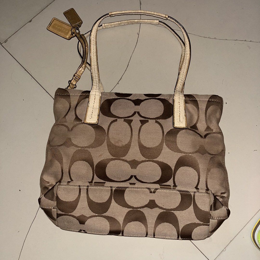 Coach Signature Tote Bag (Category: Luxury Bags & Wallets) located in Paranaque City. Submitted by flees.thrift10 (Listing ID 1424430501, Image 2). Description: - Coach tote bag - Signature pattern - Dual top handles - Zip closure - Coach hang tag - Gold-tone accent stripe - Minor wear on handles (Tinanggal na yung leather sa handle niya) - Wear on interior label .