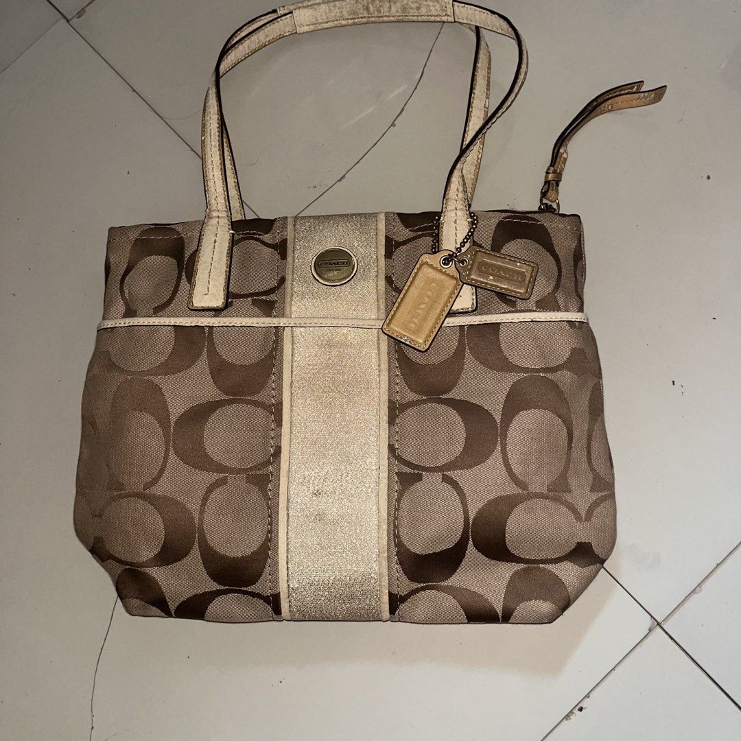 Coach Signature Tote Bag (Category: Luxury Bags & Wallets) located in Paranaque City. Submitted by flees.thrift10 (Listing ID 1424430501, Image 1). Description: - Coach tote bag - Signature pattern - Dual top handles - Zip closure - Coach hang tag - Gold-tone accent stripe - Minor wear on handles (Tinanggal na yung leather sa handle niya) - Wear on interior label .