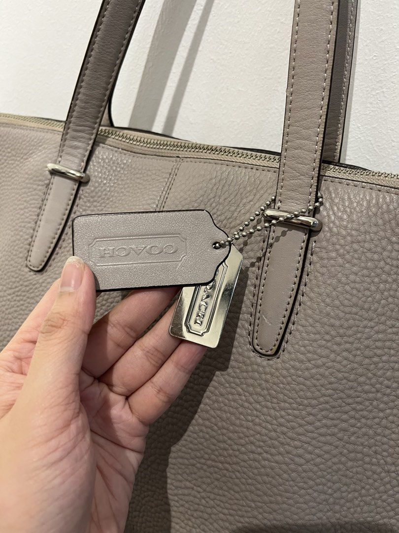 Coach Tote Bag with Shoulder Strap (Category: Luxury Bags & Wallets) located in Bacolod City. Submitted by gin.knee (Listing ID 1424470917, Image 2). Description: - Coach tote bag - Neutral grey color - Detachable shoulder strap - Zip closure - Interior pockets - Coach tag included - Light beige interior lining - Made of leather.