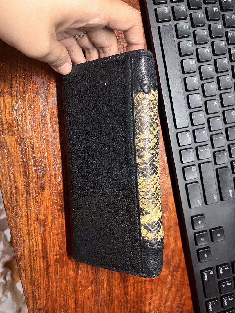 DAKS Snakeskin/leather Long wallet (Category: Luxury Bags & Wallets) located in Pasig City. Submitted by joannabongoi (Listing ID 1424391851, Image 2). Description: - DAKS Long wallet - Snakeskin and black leather design - Multiple compartments: card slots, zippered pocket - Secure snap closure - Gold-toned zipper - Black leather interior - Exterior with some wear Need lang ng linis.