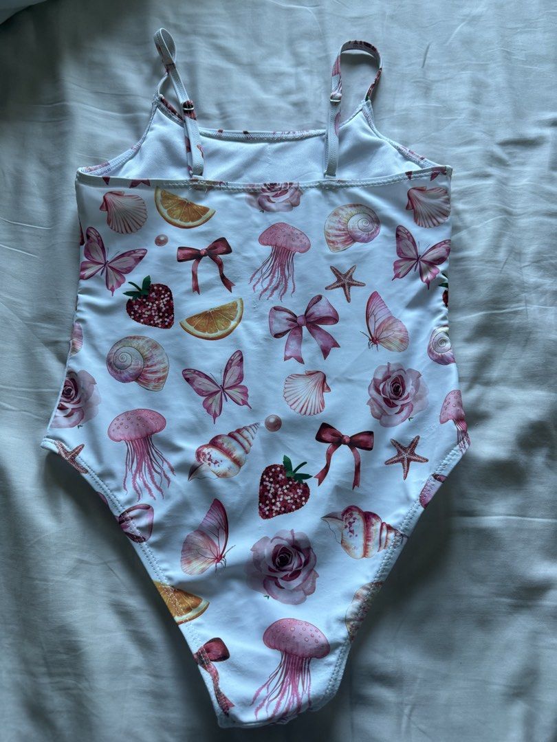 Girls' Swimsuit Size 10Y (Category: Babies & Kids Fashion) located in Taguig. Submitted by macncheese (Listing ID 1424519906, Image 2). Description: - Size: 10Y - Shein - Design: All-over print with seashells, butterflies, strawberries, and bows - Features: Adjustable straps, scoop back - Origin: Made in China.