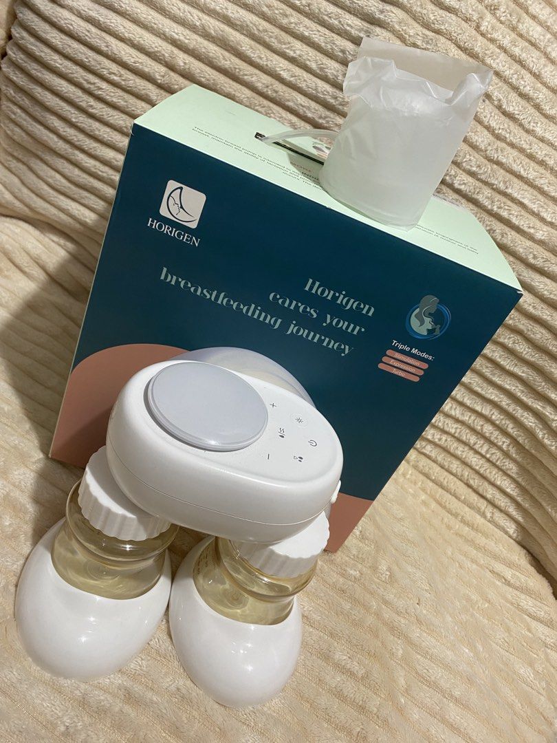 Horigen Breastfeeding Journey Breast Pump (Category: Breastfeeding & Bottle Feeding) located in Makati City. Submitted by stephlaurence (Listing ID 1424518883, Image 3). Description: - Horigen breast pump for versatile breastfeeding. - Features triple modes for different needs. - Includes: pump unit, two bottles, and other accessories. - Color: White pump with gray control panel. - Comes with the original box..