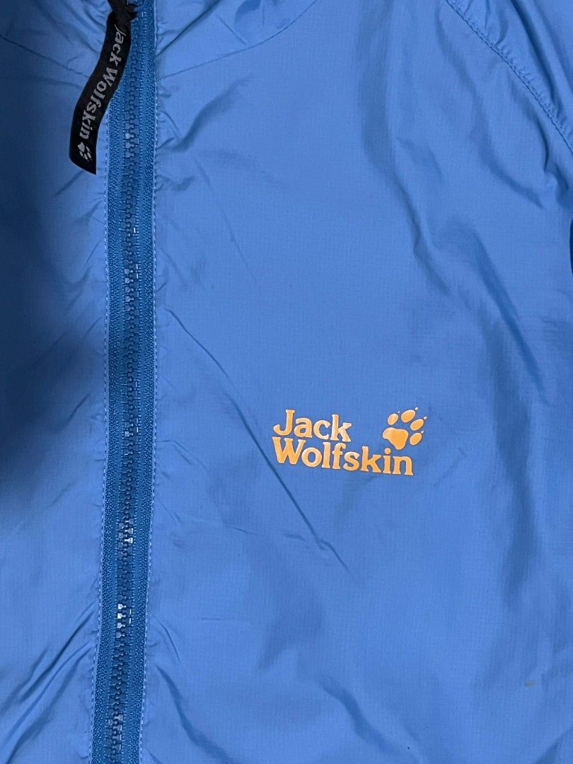 Jack Wolfskin Outdoor Jacket (Category: Coats, Jackets and Outerwear) located in Manila. Submitted by rempyyy (Listing ID 1424501280, Image 2). Description: Jack Wolfskin outdoor jacket is a vibrant blue color. It features a full zip closure, a black collar, and the Jack Wolfskin logo on the chest. The jacket has two zippered pockets and a mesh lining. The tag indicates it is an outdoor jacket..