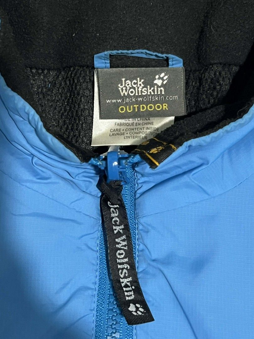 Jack Wolfskin Outdoor Jacket (Category: Coats, Jackets and Outerwear) located in Manila. Submitted by rempyyy (Listing ID 1424501280, Image 3). Description: Jack Wolfskin outdoor jacket is a vibrant blue color. It features a full zip closure, a black collar, and the Jack Wolfskin logo on the chest. The jacket has two zippered pockets and a mesh lining. The tag indicates it is an outdoor jacket..