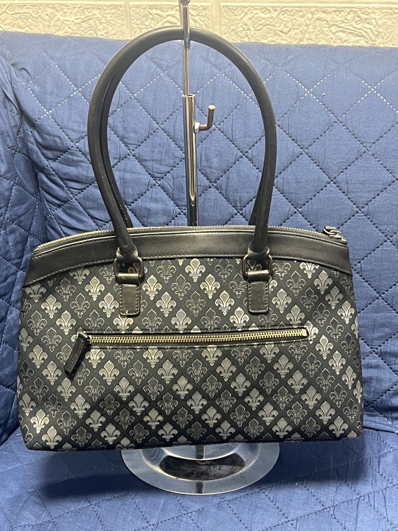 Patrick Cox London Handbag (Category: Luxury Bags & Wallets) located in General Trias. Submitted by mybag2025 (Listing ID 1424347660, Image 2). Description: - Black Patrick Cox London handbag - Fleur-de-lis pattern - Top zipper closure - Two handles - Interior zippered pocket - Gold fleur-de-lis button detail.