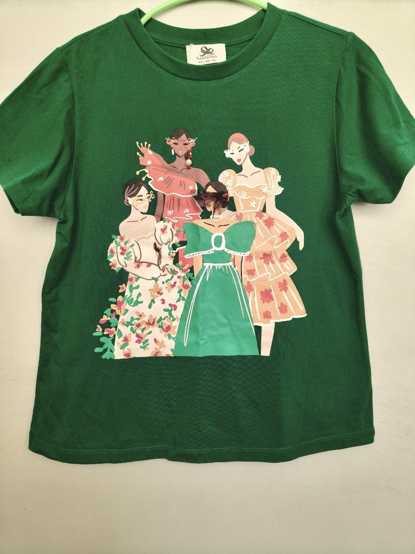 Plains & Prints Green Graphic Tee (Category: Shirts) located in Batangas. Submitted by 2mspreloved (Listing ID 1424346115, Image 1). Description: - Plains & Prints t-shirt - Green color - Features a graphic print of women in dresses - Size: PHS S, UK 6, US 4 - Short sleeves - Round neckline.