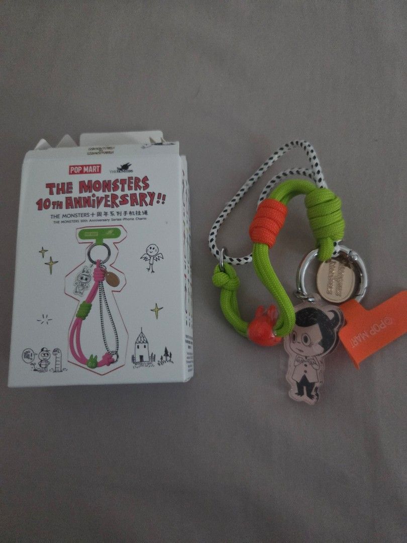 POP MART The Monsters 10th Anniversary Keychain (Category: Designer & Blind Box Toys) located in San Juan City. Submitted by simplyj18 (Listing ID 1424519425, Image 3). Description: - POP MART The Monsters 10th Anniversary Keychain - Features a unique design with a green and orange carabiner-style clip. - Includes a character charm and a small orange tag. - Comes with the original POP MART box. - Item is unused. opened box.