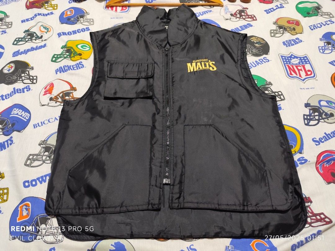 Suntory Malt's Vest - Black (Category: Vests) located in Baguio. Submitted by FRANKLIN (Listing ID 1424472915, Image 2). Description: Black vest with Suntory Malt's logo. Features a zip-up front, two front pockets, and a small pocket on the chest. The vest has a collar and is labeled as size L. Measurements are 23W x 24 Front x 26 Back. Made with 100% nylon and polyester..