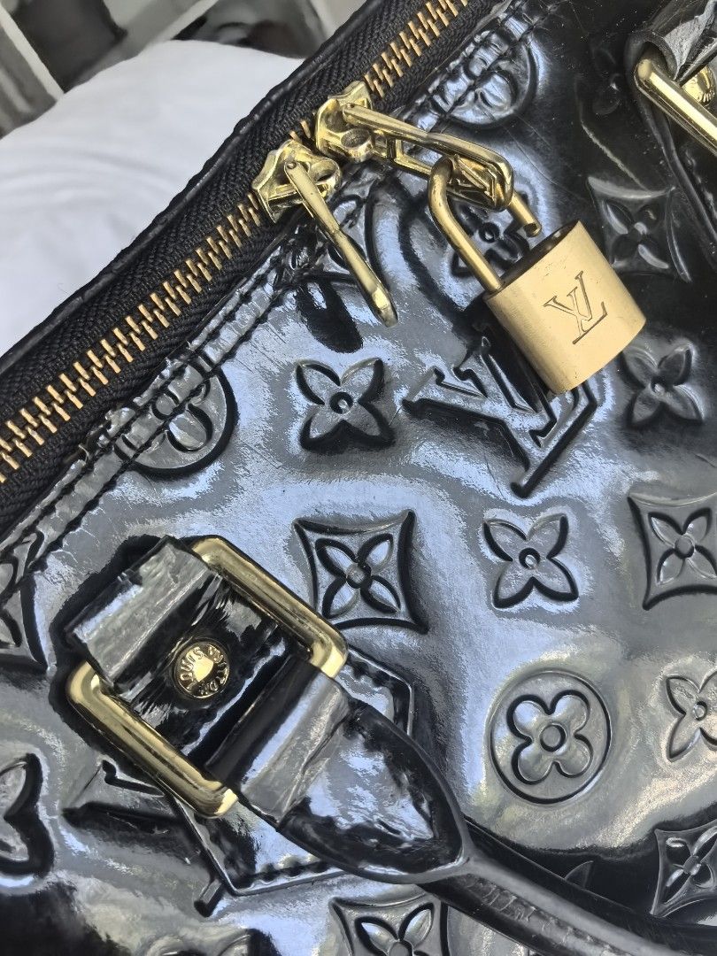 Top handle Alma Vernis Black (Category: Purses & Pouches) located in Manila. Submitted by jjh1027 (Listing ID 1424380212, Image 2). Description: - please check all flaws in the pic - Black patent leather exterior -Top handle for easy carrying - Elegant gold-tone hardware - Includes a secure padlock - Features a zip closure - Protective metal feet - Interior condition good.